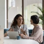 stock-photo-two-happy-engaged-business-professionals-women-brainstorming-on-online-project-at-laptop-speaking-2258472079